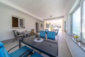a living room with a table and blue chairs at Rooms and Apartments Lidija in Lopar