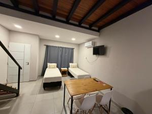 a room with a bed and a table and chairs at LOS LIRIOS in Puerto Iguazú