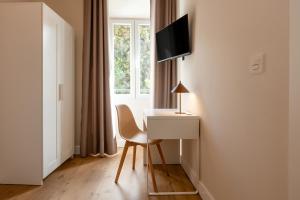 a room with a desk and a chair and a window at Hospedería Boho Granada by eme hoteles in La Zubia