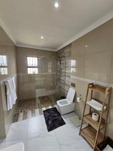 a bathroom with a toilet and a shower at Posimuma in Centurion