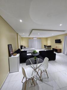a living room with a couch and a table and chairs at Posimuma in Centurion +4 photos
