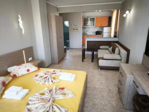 a bedroom with two beds and a living room at Guesthouse Kamelia in Ahtopol