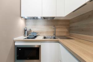 a kitchen with white cabinets and a sink at Il Chiostro di Santa Caterina in Vimercate +42 photos