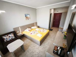 a small bedroom with a yellow bed and a chair at Guesthouse Kamelia in Ahtopol