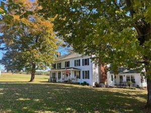a white house with trees in front of it at The Hutch in Bardstown