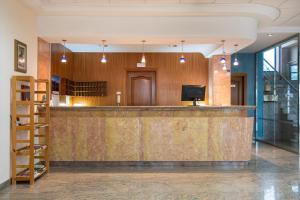 a lobby with a bar with a tv on it at Checkin Basic León Norte in León