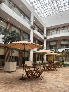 a courtyard with tables and umbrellas in a building at Casa Américas in Mexico City