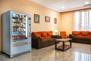 a living room with a refrigerator filled with drinks at Checkin Basic León Norte in León