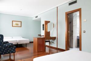 a bedroom with a mirror and a bed and a chair at Checkin Basic León Norte in León +29 photos