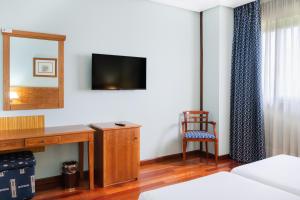 a hotel room with a desk and a mirror at Checkin Basic León Norte in León