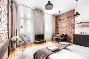 a room with a bed and a brick wall at MARGI Igram - Martini - Absynth Apartments LARGE & COMFY in Szczecin