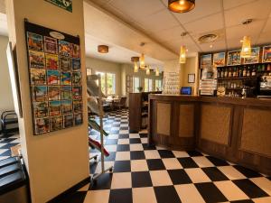 a bar in a restaurant with a checkered floor at Hotel VTF Clairefont - Bandol in Bandol