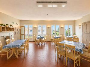 a dining room with tables and chairs and windows at Hotel VTF Clairefont - Bandol in Bandol