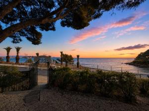 a gate leading to the beach at sunset at Hotel VTF Clairefont - Bandol in Bandol