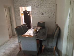 a dining room table with chairs and a refrigerator at Pousada Mais E Vida 24h in Teresina +8 photos