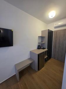 a room with a bench and a flat screen tv at Falirala Central in Faliraki