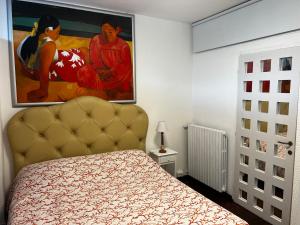 a bedroom with a bed and a painting on the wall at Studio Naty in Marina di Massa