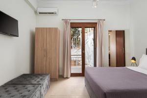 a bedroom with a bed and a sliding glass door at Utopia Suites in Egina