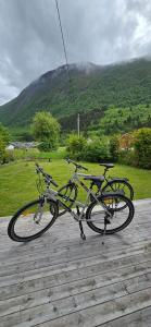 a bike parked on a wooden deck with a mountain in the background at Reinebu in Ørsta