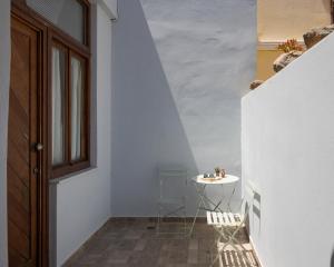 a hallway with a table and chairs and a door at Utopia Suites in Egina +21 photos