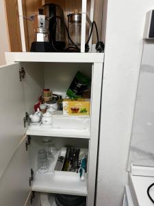 a cupboard with food and other items in it at Studio Naty in Marina di Massa +10 photos