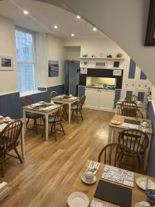 a restaurant with tables and chairs and a kitchen at Awel Mor in Criccieth