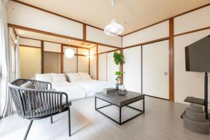 a bedroom with a bed and a chair and a table at gently stay Nagoya in Nagoya