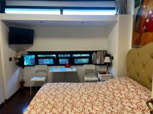 a bedroom with a bed and a table and four monitors at Studio Naty in Marina di Massa