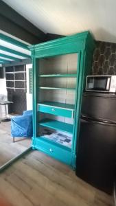 a green cabinet in a kitchen next to a refrigerator at Maisonnette mitoyenne andernos in Andernos-les-Bains +18 photos