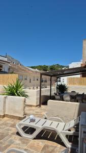 a white chaise lounge on a patio with a table and chairs at Mi Casa 4 in Jávea