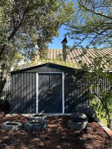 a black building with a door and some rocks at Romantic Tulbagh Getaway in Tulbagh