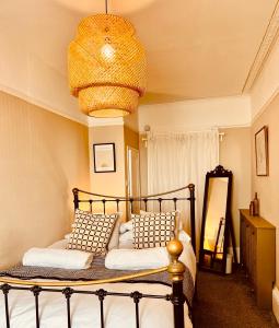 a bedroom with a bed and a chandelier at Stunning seafront apartment in Brighton & Hove