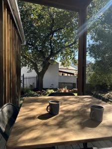 a table with two coffee cups sitting on top of it at Romantic Tulbagh Getaway in Tulbagh +6 photos