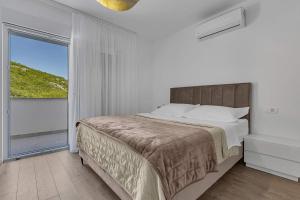 a bedroom with a bed and a large window at Villa Magdalena in Zavojane +34 photos