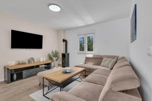 a living room with a couch and a tv at Villa Magdalena in Zavojane