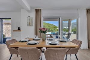 a dining room with a wooden table and chairs at Villa Magdalena in Zavojane