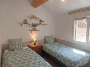 a bedroom with two beds and a window at La Fontchaude, gîte de charme au cœur de la nature à Cabrespine in Cabrespine