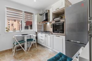 a kitchen with white cabinets and a table in it at Nest45 in Roşu