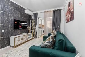 a living room with a green couch and a tv at Nest45 in Roşu