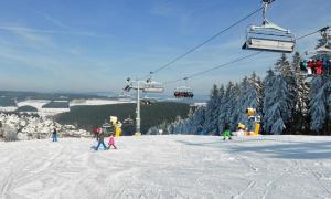 a group of people on a ski lift in the snow at Bödefeld in Schmallenberg