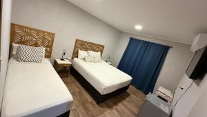 a bedroom with two beds and a blue curtain at LOS LIRIOS in Puerto Iguazú +42 photos