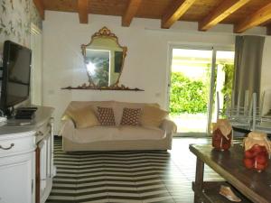 a living room with a couch and a mirror at Orchidea in Beverino