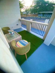 a balcony with a chair and a table and grass at Jaden's Guest House in Saint Michael