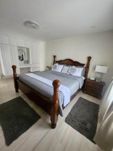 a bedroom with a large bed with a wooden frame at Jaden's Guest House in Saint Michael