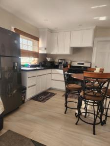 a kitchen with white cabinets and a table and chairs at Jaden's Guest House in Saint Michael