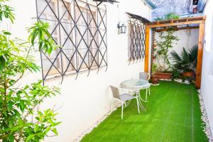 a patio with green grass and a table and chairs at HYGGE FORMOSA in Formosa