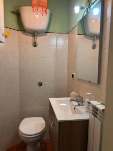 a bathroom with a toilet and a sink and a mirror at Civico 15 in Antrosano +16 photos