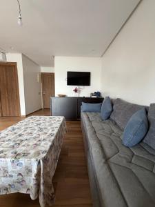 a living room with a couch and a tv at Odyssée Atlantique Blue beach - Sidi Rahal - famille seulement in Sidi Rahal