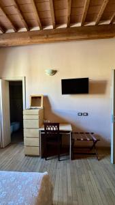 a bedroom with a desk and a tv on the wall at La Rosa Garden in Campi Bisenzio