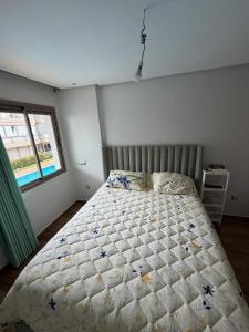 a bedroom with a bed and a window at Odyssée Atlantique Blue beach - Sidi Rahal - famille seulement in Sidi Rahal +14 photos